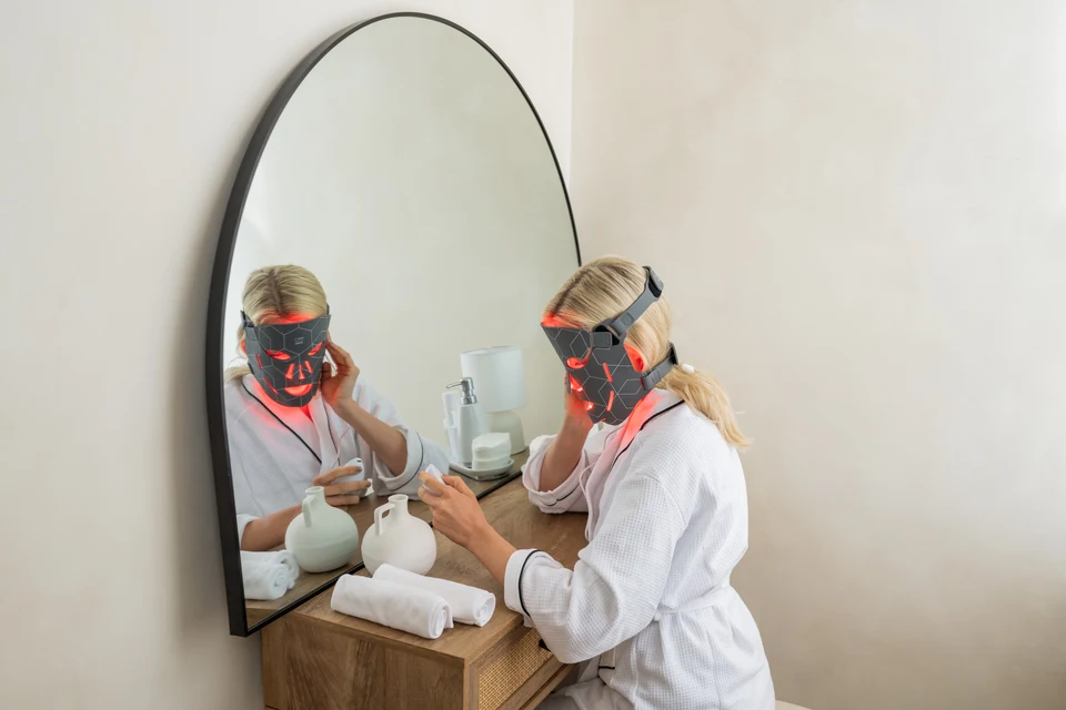 Gedragen FaceLITE PRO-masker met de controller in de hand bij een spiegel