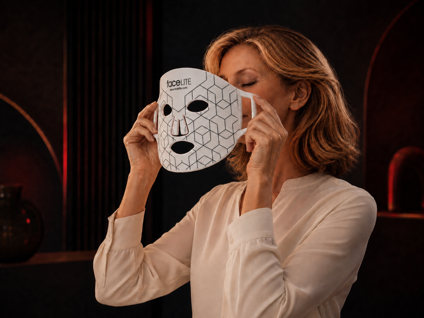 Vrouw plaatst het witte FaceLITE LED-gezichtsmasker op haar gezicht